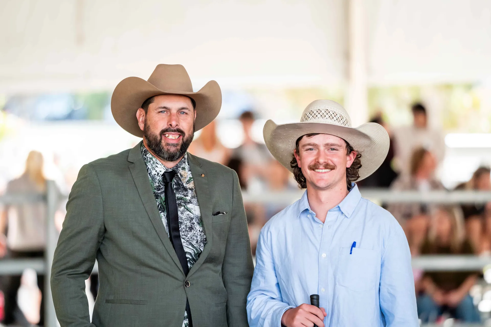 Two smiling participants in cowboy hats at a Royal Agricultural Society of WA event, celebrating rural tradition and community spirit.