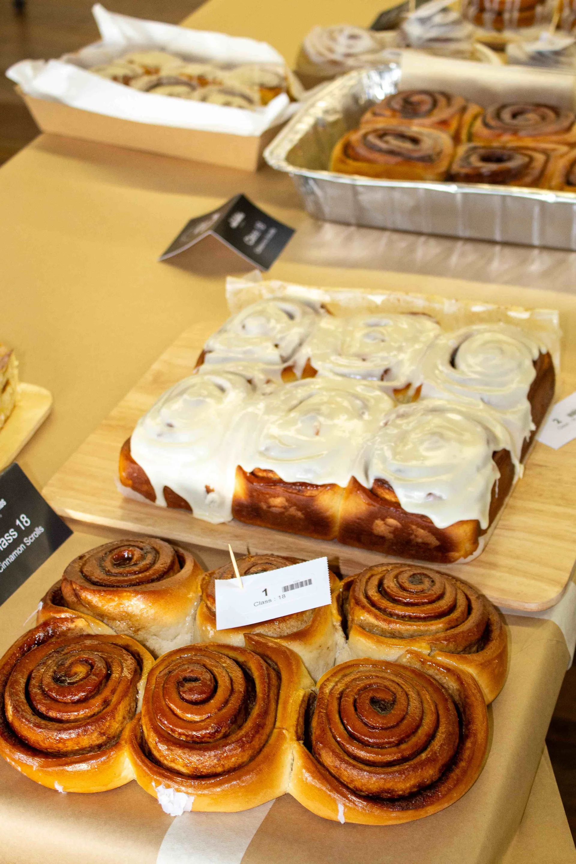 A variety of cinnamon scroll entries on display at the Perth Royal Food Awards, showcasing presentation, icing, and baking quality for judging.