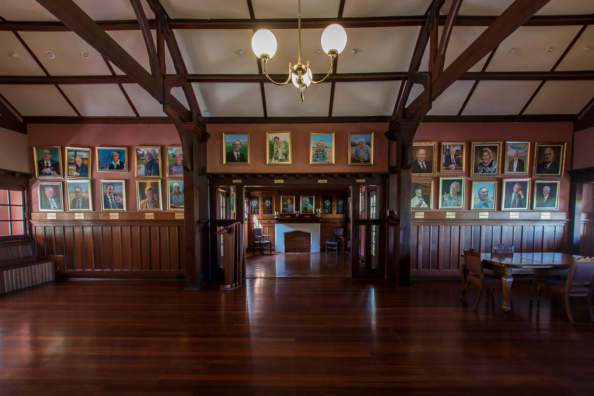 Interior of a heritage hall with portraits displayed on the walls