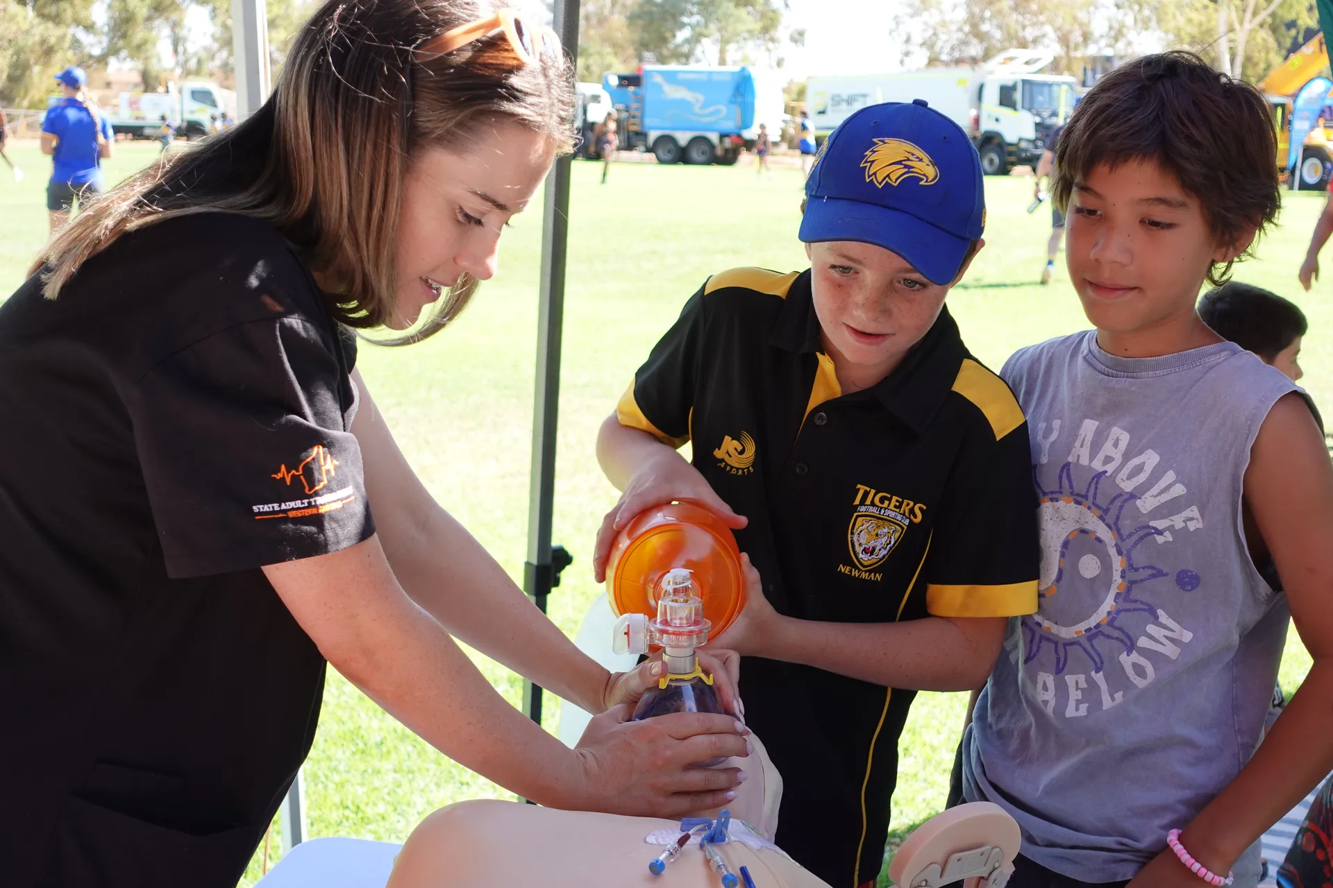 young adults learning how to give oxygen to dummy 