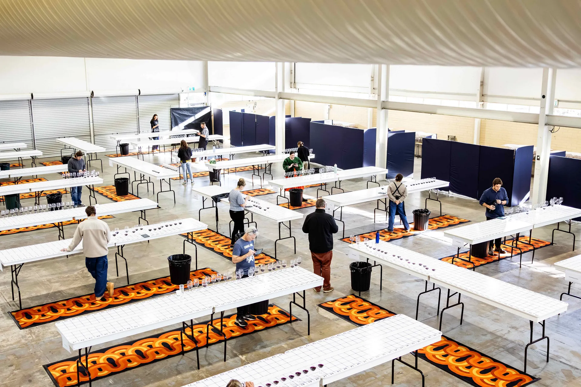 Overhead view of judges seated at tables with wine glasses during a Perth Royal Food Awards judging session