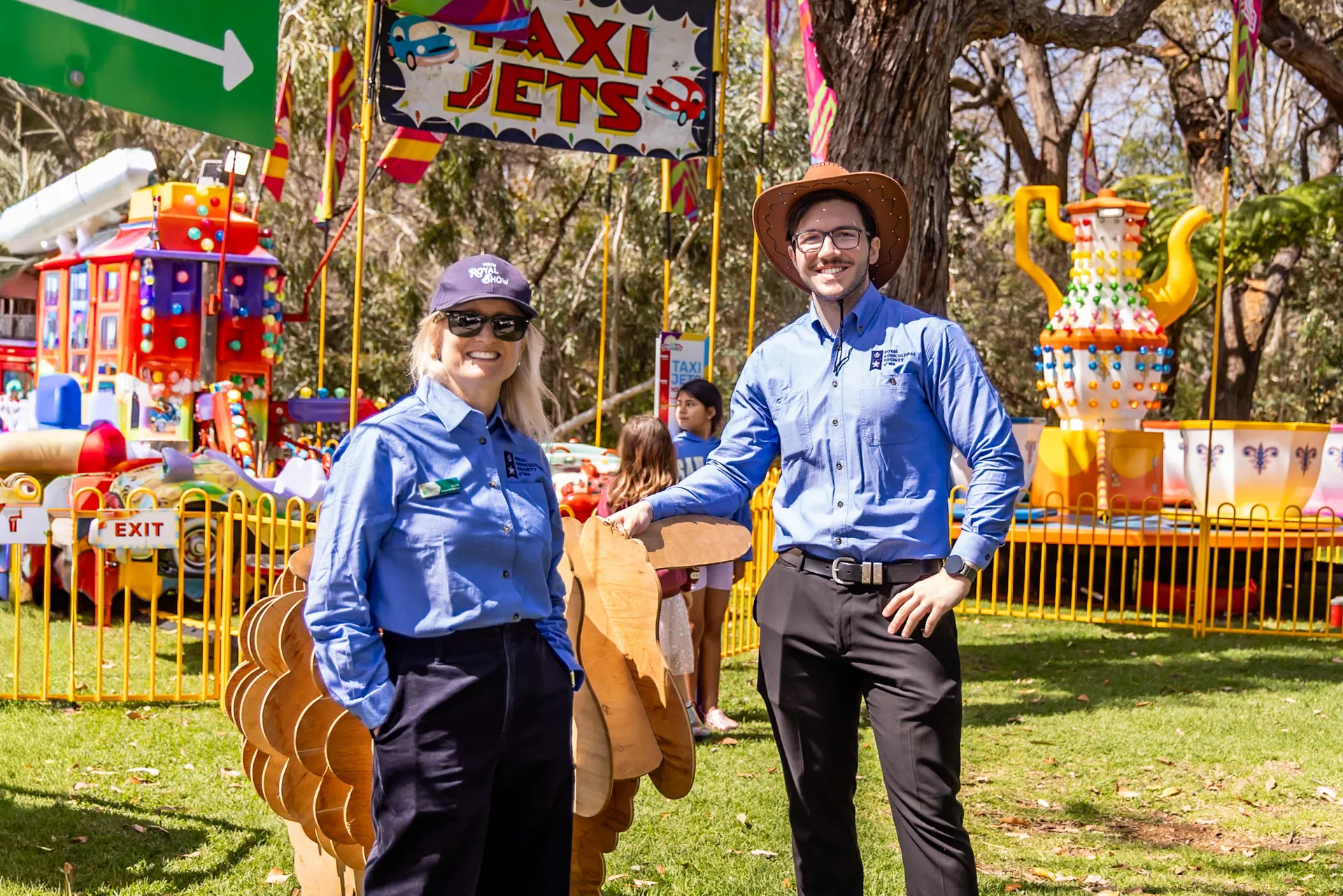 Two staff members standing in front of a children’s rides