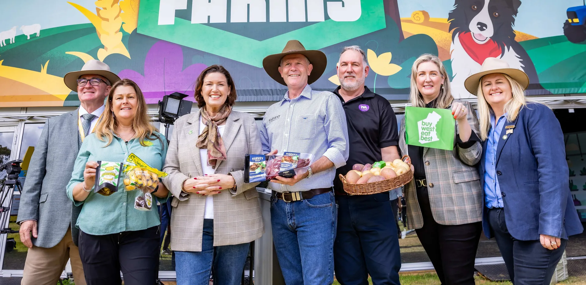 Group of people standing in front of a “Smart Farms” display at an agricultural event