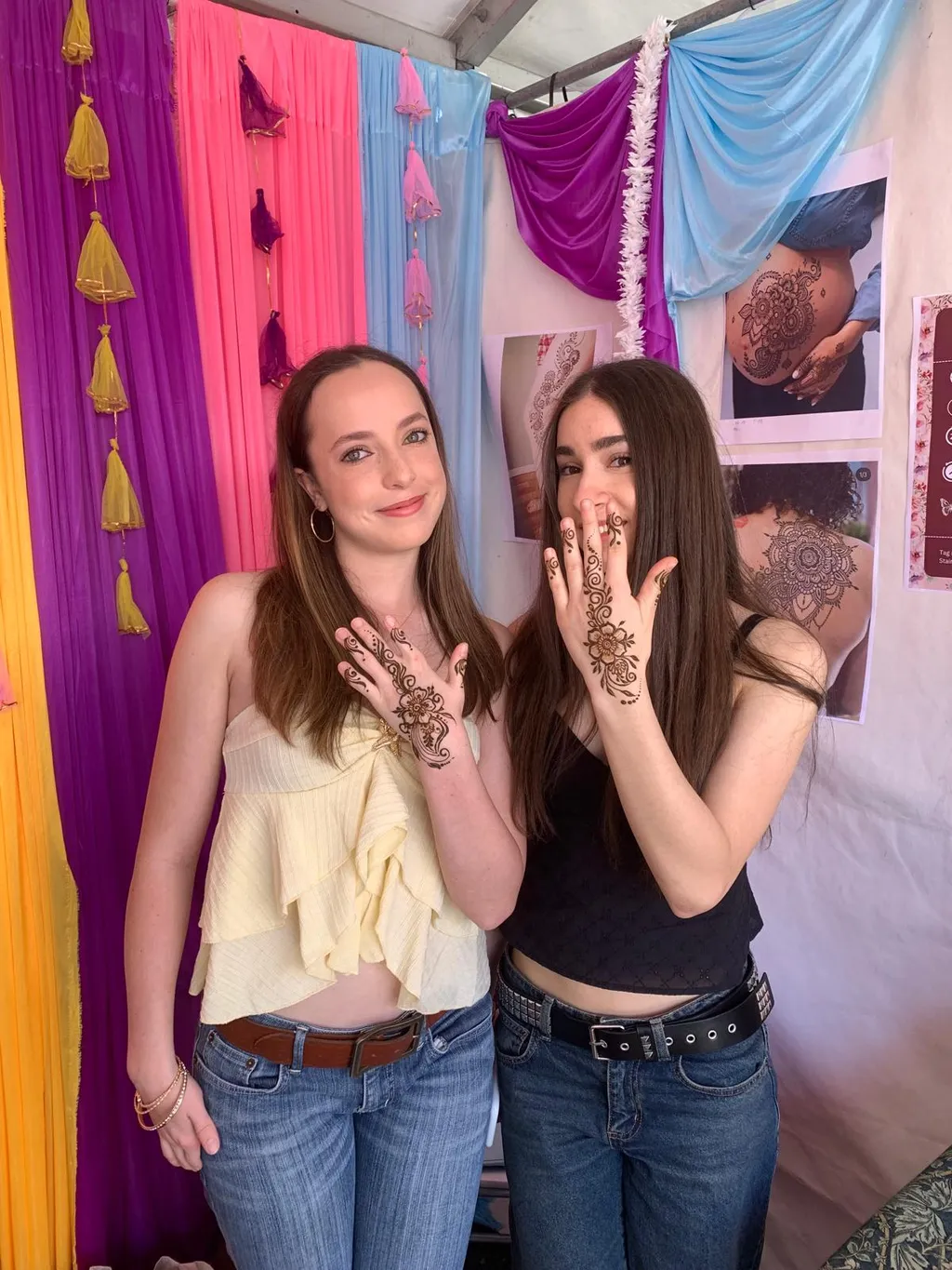 two girls showing their floral henna