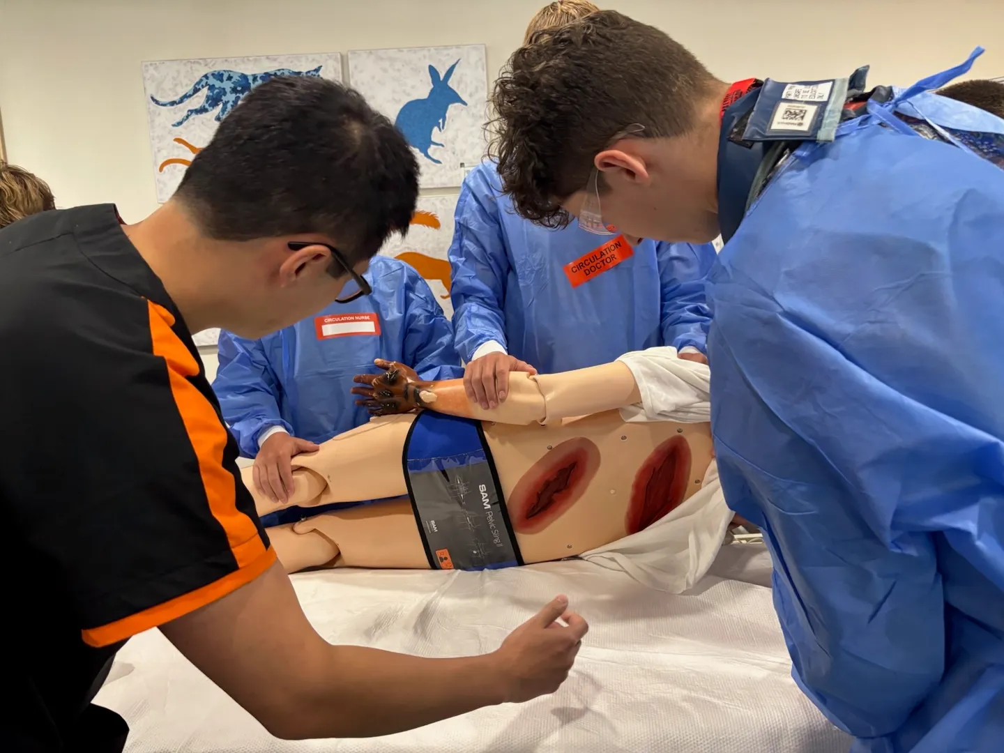Young Adults performing medical assistance to injured dummy