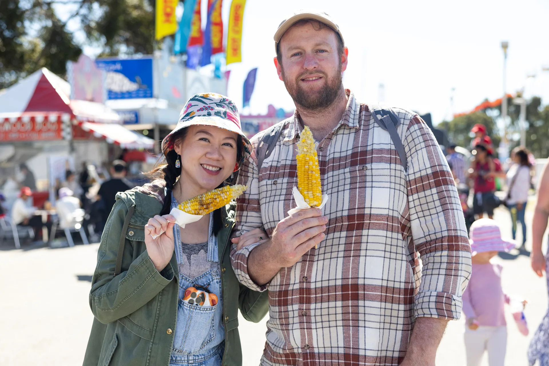 Woman and man eating corn cobs at Show
