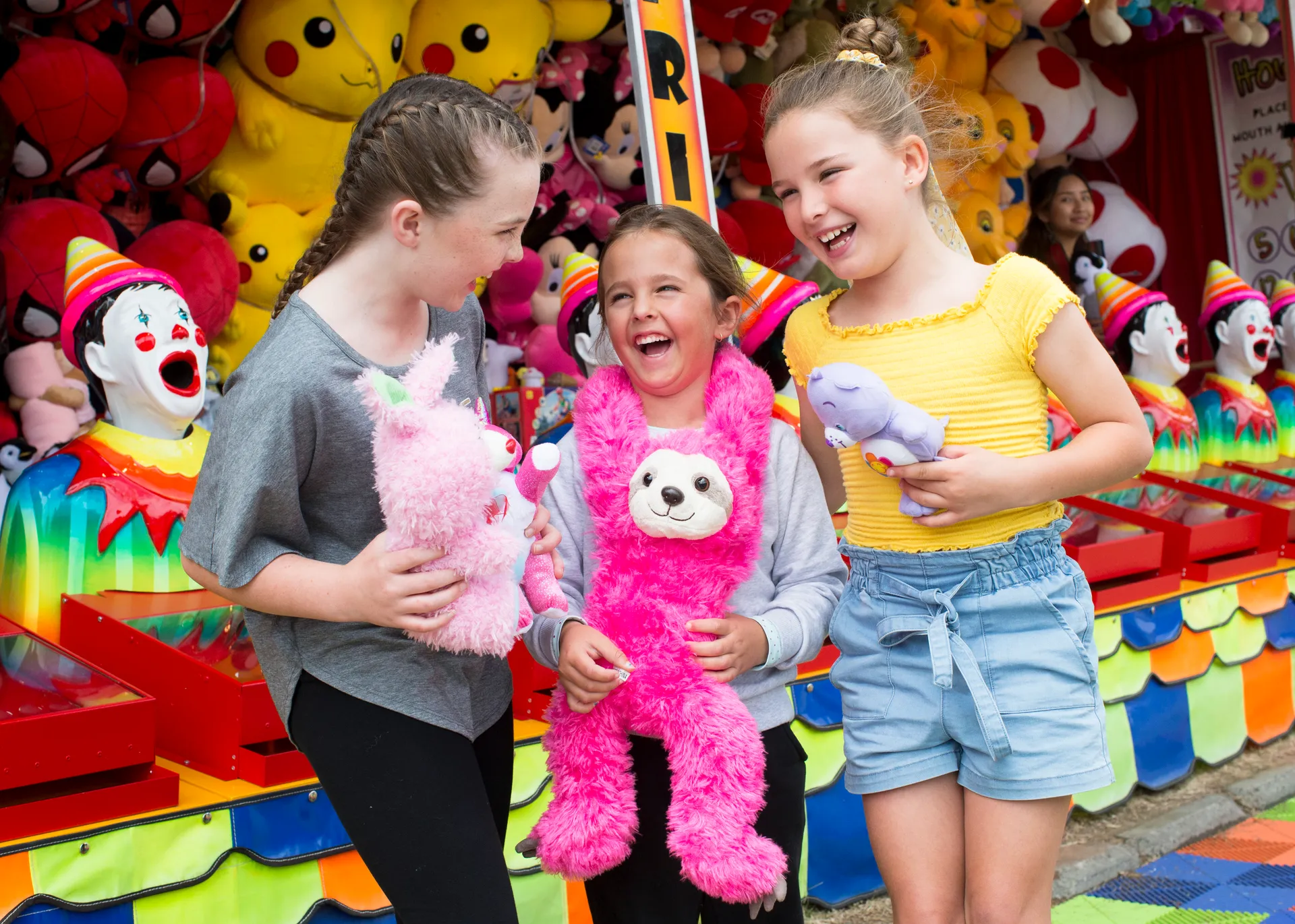 Children in front of a carnival game stall filled with plush toys at the Perth Royal Show.