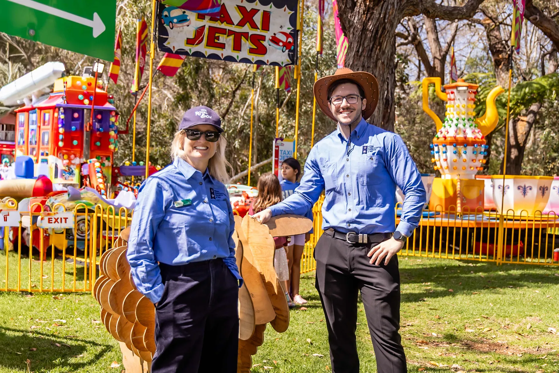 Two staff members standing in front of a children’s rides