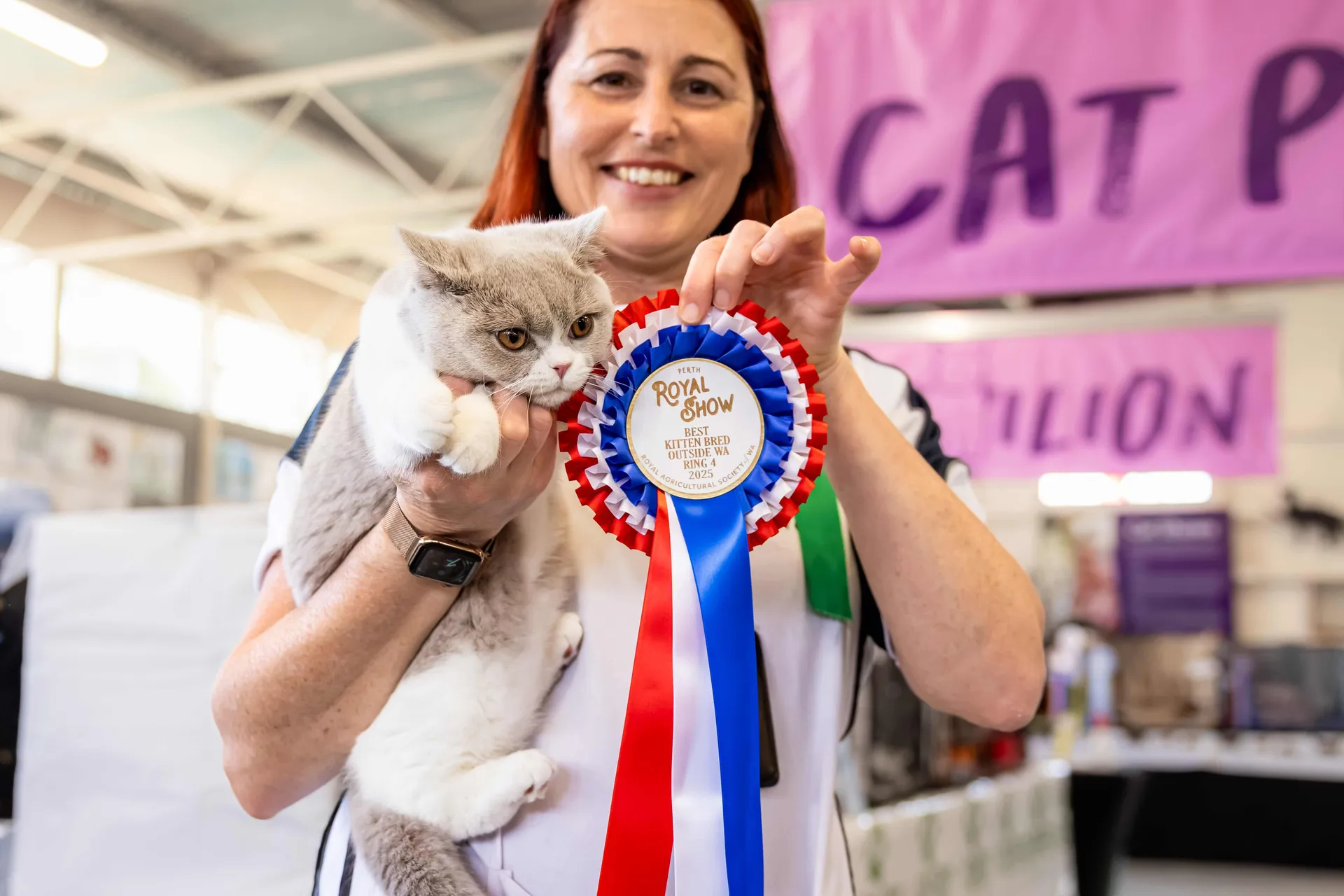 Woman holding a cat and displaying a prize ribbon at the Perth Royal Show