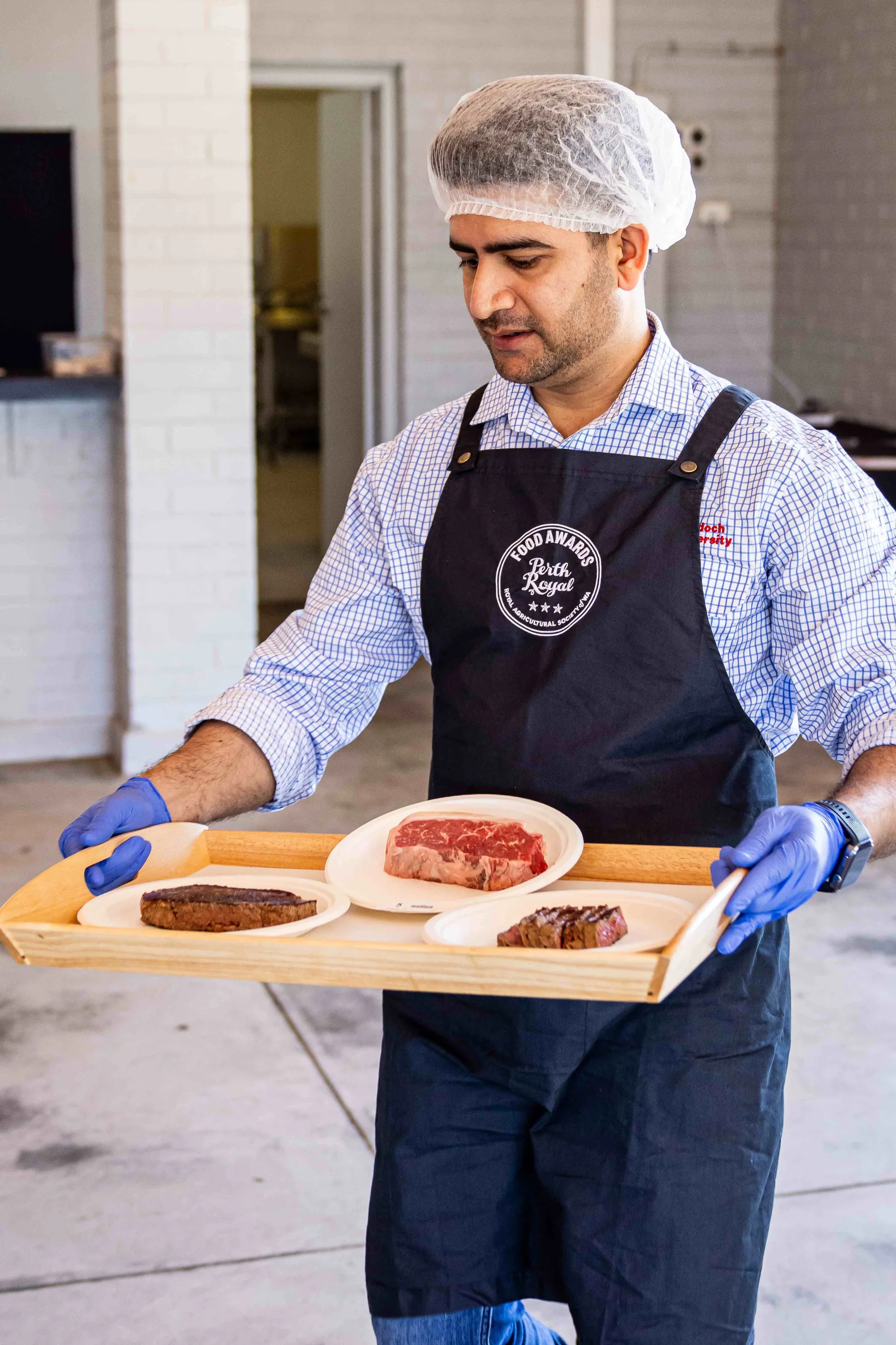 Staff member carrying steak samples for judging at the Perth Royal Food Awards.