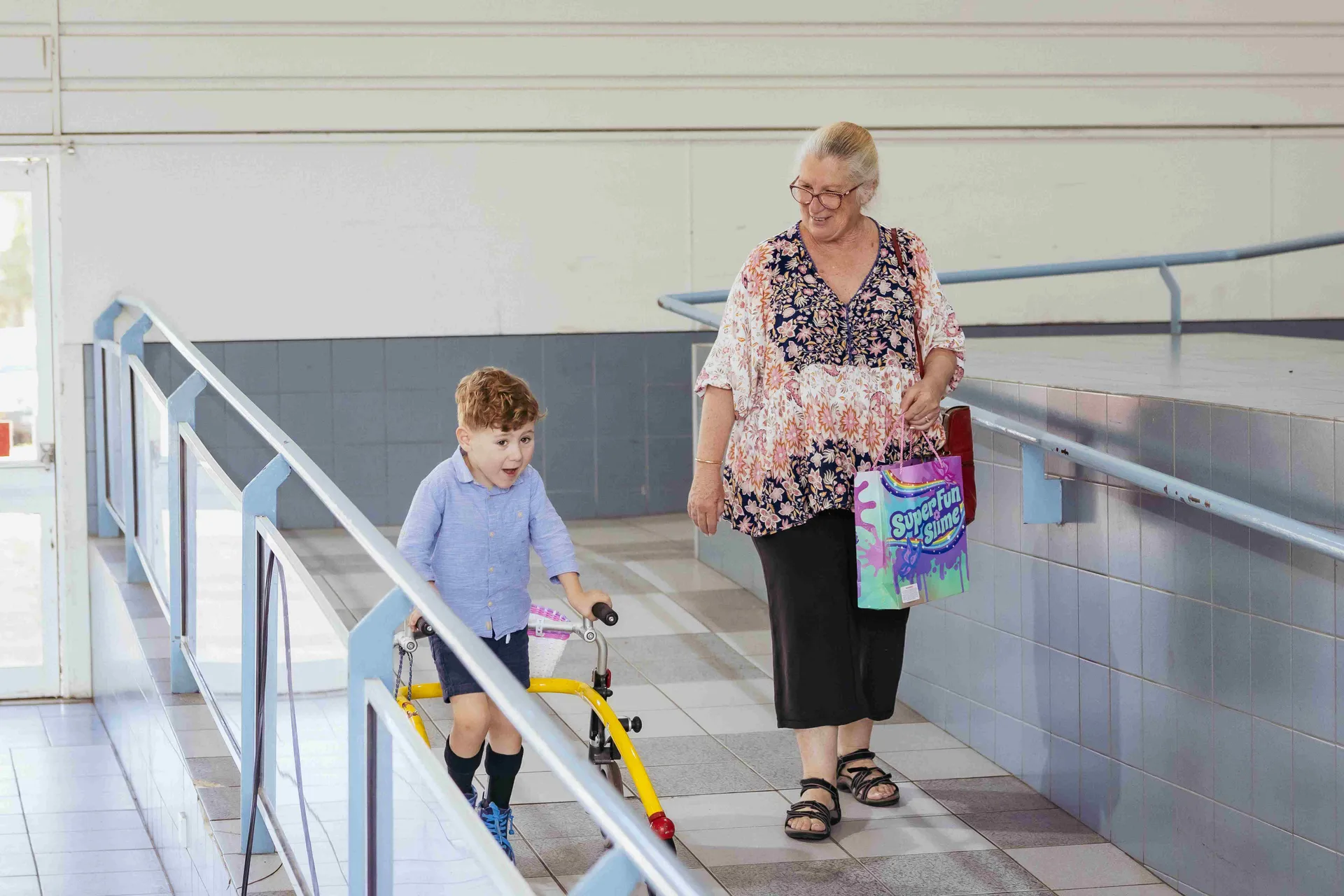 Child using a walker with an adult at Claremont Showground.