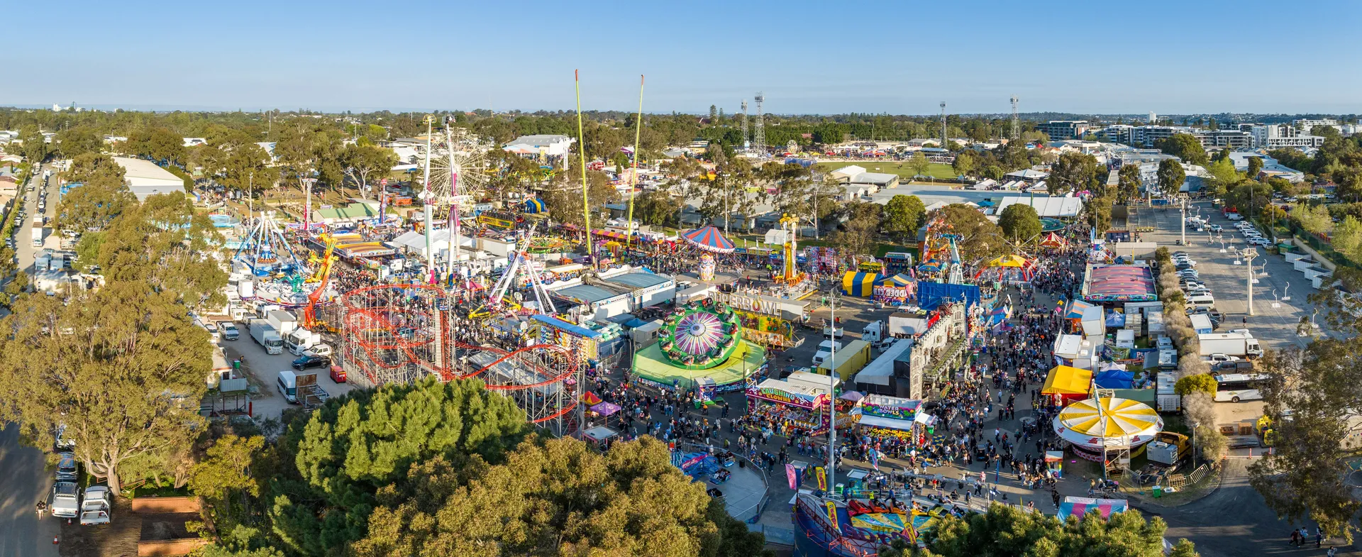 Aerial view of a large event with rides, stalls and crowds at Claremont Showground